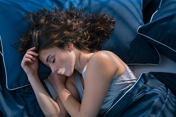 Woman sleeping with DreamTape mouth tape for nasal breathing