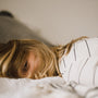 Woman resting on her side in a calm, bright bedroom