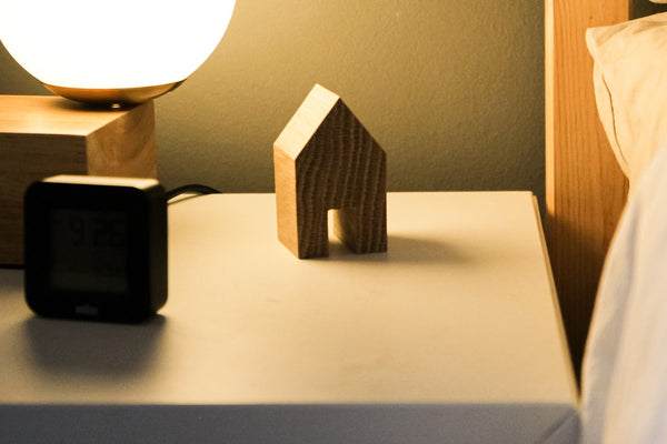 Alarm clock on a nightstand beside a bed at night