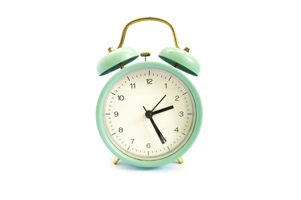 An alarm clock beside a bed