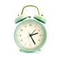 An alarm clock beside a bed