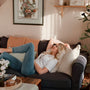 A woman resting on a couch in a living room
