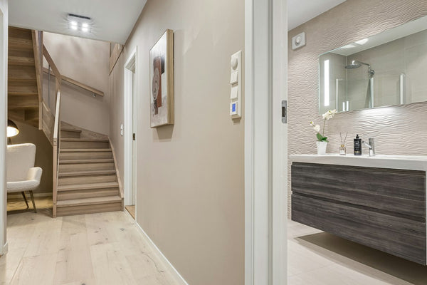A hallway leading to a bathroom with a toilet and sink