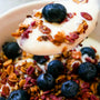 A bowl of yoghurt with granola and blueberries