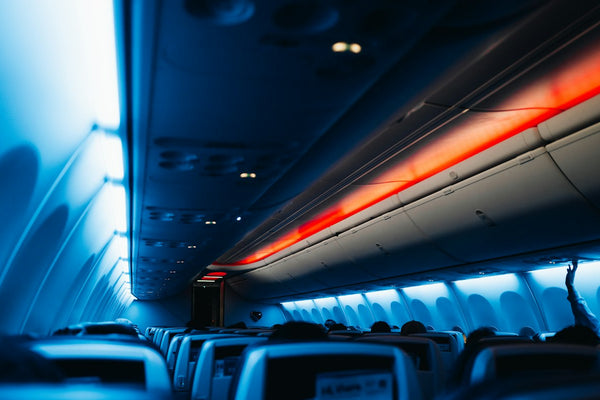 Dimly lit aeroplane cabin with rows of seats on a long flight