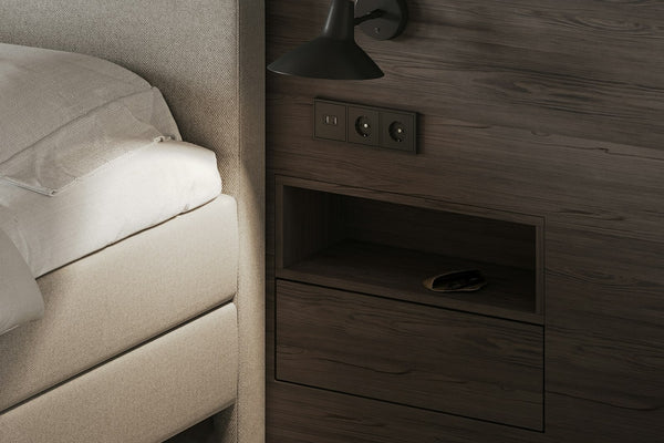 A calm, tidy bedroom with a made bed, nightstand and soft natural light from a window