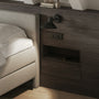 A calm, tidy bedroom with a made bed, nightstand and soft natural light from a window