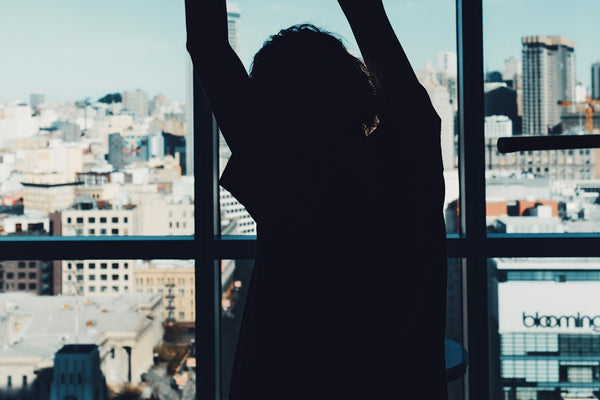 Person stretching by a bright window in the morning