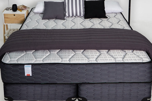 A neatly made bed with a soft blanket and pillows in a calm bedroom