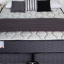 A neatly made bed with a soft blanket and pillows in a calm bedroom