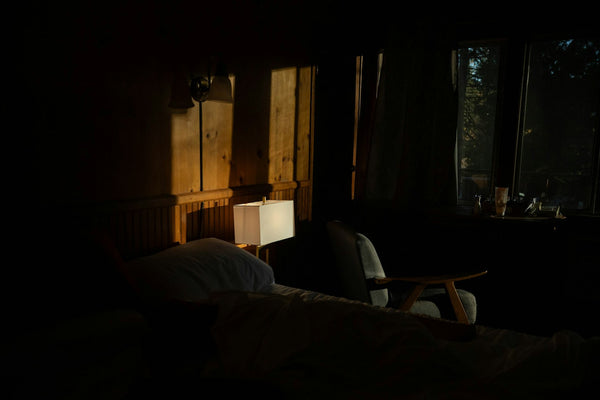 Dimly lit bedroom with soft golden morning light coming through the window