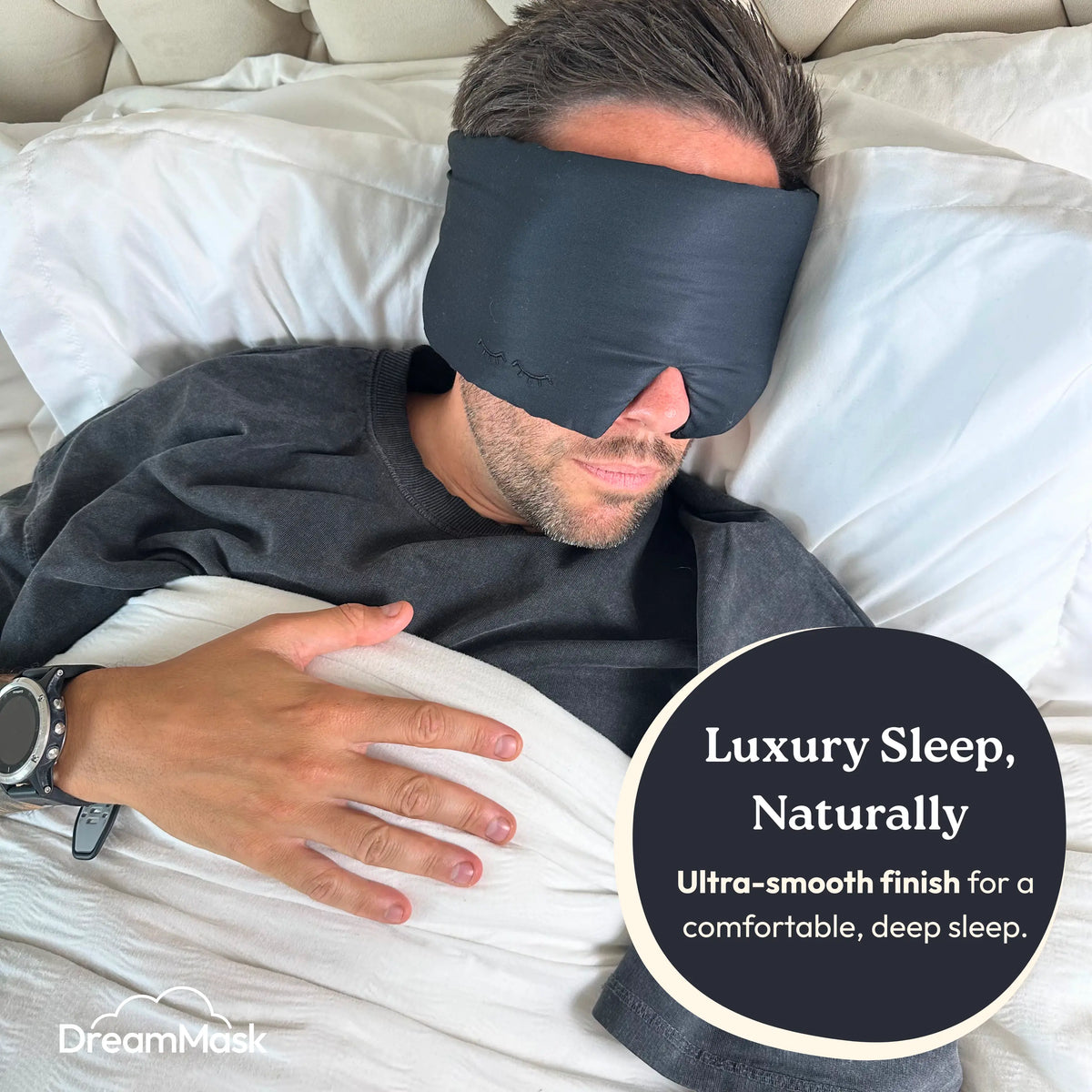 Man wearing a sleep mask in bed with 'DreamMask' branding.
