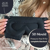 Black sleep mask held by a person with text highlighting its features, brand 'DreamMasks' visible.