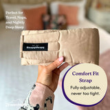 Beige travel pillow held by a hand with 'Sleepy Deepy' branding, set against a blurred bedroom background.