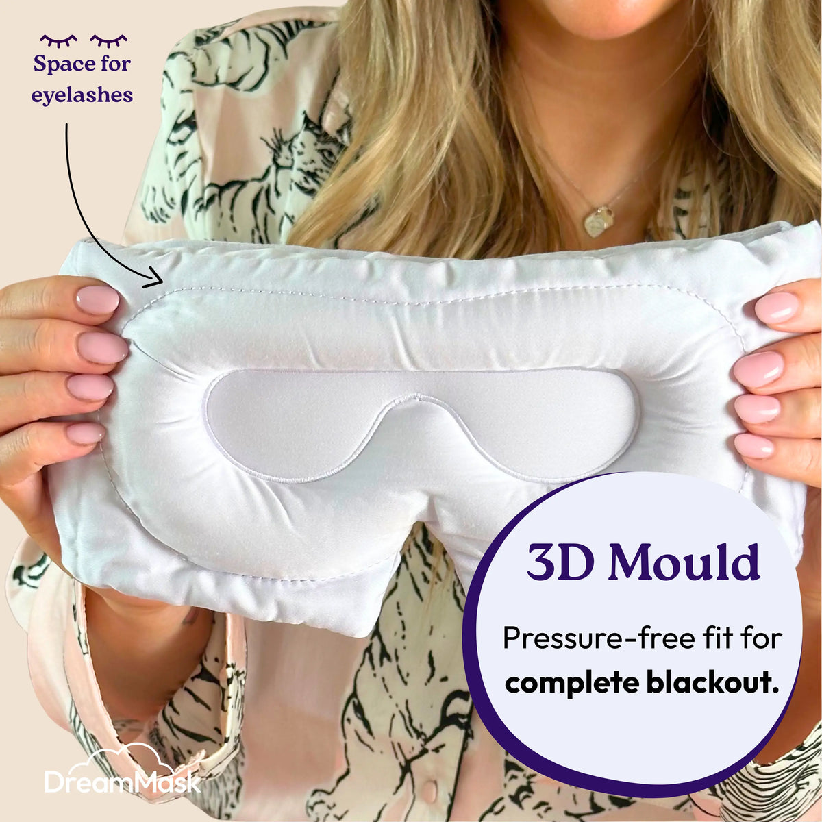 Person holding a white sleep mask with 3D mould feature, labeled 'DreamMask'.