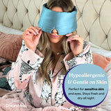 Woman wearing a blue sleep mask with promotional text about its hypoallergenic and gentle properties.