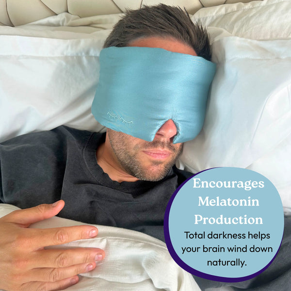 Person wearing a blue sleep mask in bed with text about melatonin production.
