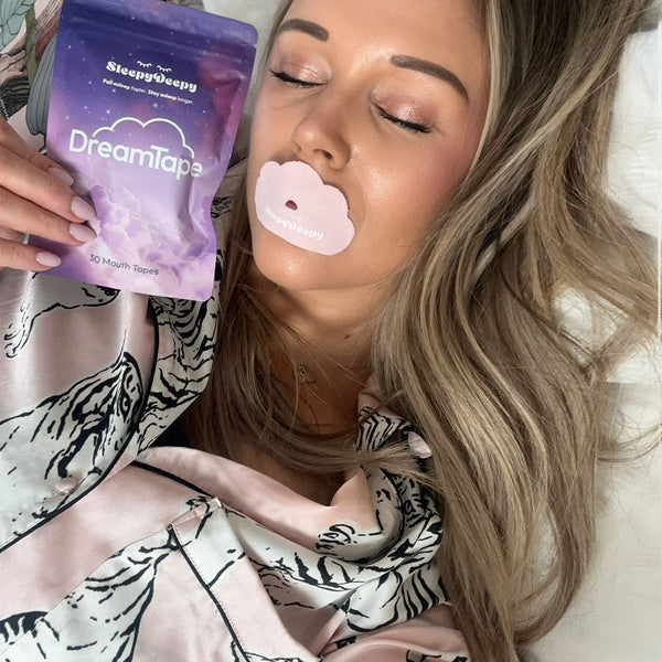 Person holding a package of DreamTape with a pink mouth tape on